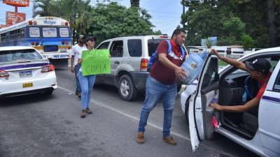 Con botellones en mano y carteles de un SOS Curla, los alumnos piden la colaboración a los conductores de vehículos.