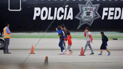 Un grupo de migrantes hondureños que hacía parte de la caravana rumbo a EE.UU. llega en un avión de la policía mexicana al aeropuerto Ramón Villeda Morales, cerca de San Pedro Sula (Honduras). EFE/ José Valle