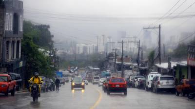 Fotografía que muestra vehículos mientras circulan bajo la lluvia de ayer jueves en Tegucigalpa (Honduras). EFE/Gustavo Amador