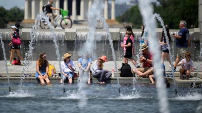 Visitantes se refrescan en la fuente de uno de los monumentos en Washington D.C.
