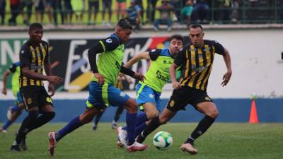 Ángel Villatoro del Olancho FC conduce el balón ante la marca del zaguero Devron García del Real España.