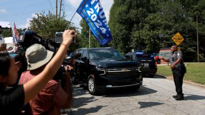 Seguidores de Trump esperan al exmandatario en las afueras de la cárcel del condado de Fulton en Georgia.