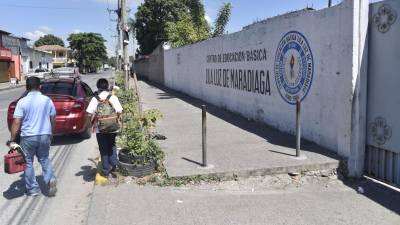 Un padre y su hijo caminan frente a la escuela Lila Luz de Maradiaga al finalizar la jornada escolar.