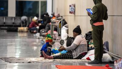 Familias migrantes duermen en la terminal E del Aeropuerto Internacional de Boston.