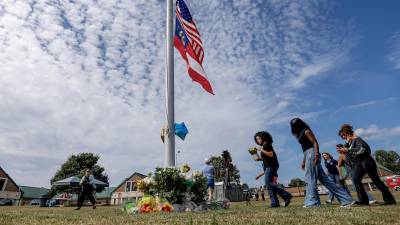 Los dolientes hacen una pausa en un monumento improvisado, un día después del tiroteo mortal en la escuela secundaria Apalachee en Winder, Georgia, EEUU.