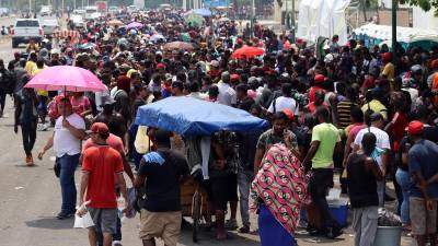 Migrantes hacen fila para tramitar papeles migratorios hoy, en Tapachula (México).