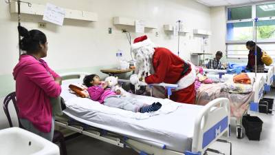 El Santa Claus sampedrano conversa con una niña en la sala de Pediatría del Rivas. Fotos: Héctor Edú