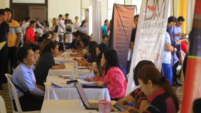 Representantes de empresas entrevistan a solicitantes en una feria de empleo en Plaza Las Banderas.
