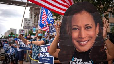 Fotografía de archivo de una persona que usa una gran máscara con el rostro de la vicepresidenta Kamala Harris durante un encuentro de miembros de la comunidad hispana en Miami, Florida.