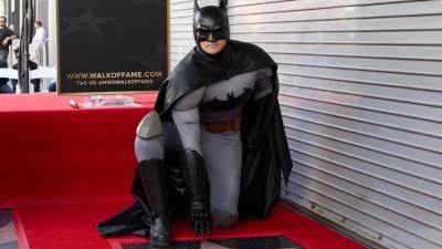 Un actor que se hace pasar por el personaje de Batman se arrodilla sobre su recién inaugurada estrella en el Paseo de la Fama de Hollywood después de una ceremonia en honor al superhéroe en Los Ángeles, California, EE.UU.