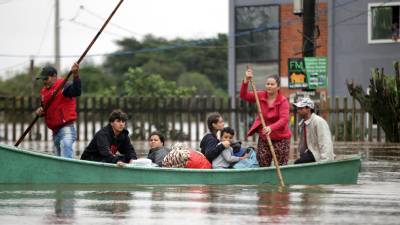 Algunos moradores son rescatados del sector de Isla de la Pintada, que sufre con la subida del agua por las lluvias este viernes, en Porto Alegre (Brasil).