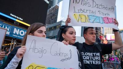 Venezolanos se manifiestan con pancartas, en el Time Square en Nueva York.