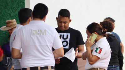 Personal del Instituto Nacional de Migración (INM) habla con migrantes en el municipio de Huehuetán (México).