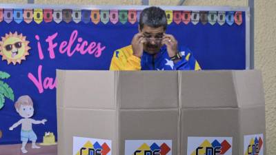 El presidente y candidato presidencial venezolano, Nicolás Maduro, ajusta sus anteojos mientras vota durante las elecciones presidenciales, en Caracas, el 28 de julio de 2024.