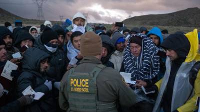 Un agente de la Patrulla Fronteriza recibe información de un grupo de migrantes en la frontera sur de EEUU.
