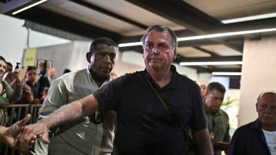 El expresidente de Brasil, Jair Bolsonaro (2019-2022) saluda al finalizar una rueda de prensa el lunes, en el Aeropuerto Internacional Juscelino Kubitscheck, en Brasilia.
