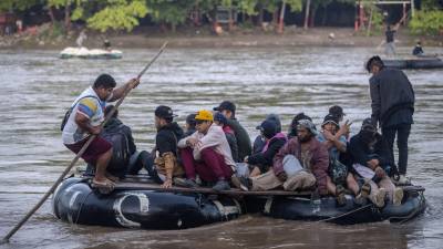 Los migrantes cruzan en balsas improvisadas el río Suchiate en la frontera de Guatemala y México.