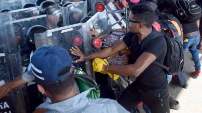 La Guardia Nacional de México intentó impedir el paso a los migrantes que desbordaron a las autoridades.
