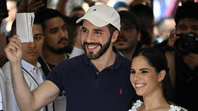 Bukele y su esposa, Gabriela, posan ante los medios al depositar su voto en las elecciones municipales de Ecuador.