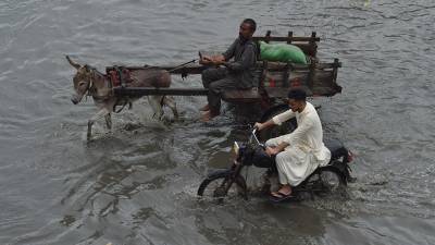 La gente camina por una carretera inundada después de fuertes lluvias en Karachi, Pakistán, el 18 de agosto de 2024.