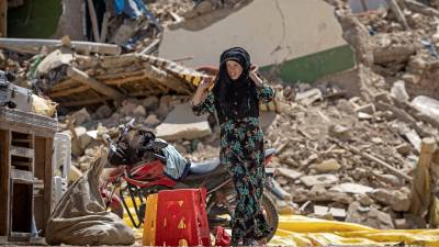Mujer carga sus pertenencias extraídas de los escombros tras el sismo que sacudió el pasado viernes la ciudad de Marruecos.
