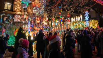 Personas visitan decoraciones navideñas puestas en las entradas de casas, en el barrio residencial de Dyker Heights, al sur de Brooklyn, Nueva York (EE. UU).