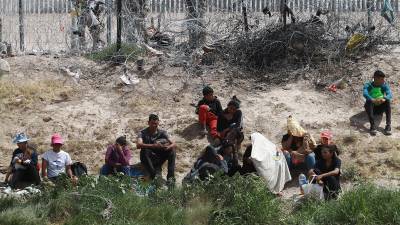Personal de la Guardia Nacional de Texas vigila a un grupo de migrantes.