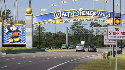 Fotografía de automóviles que pasan bajo una de las puertas de acceso a Walt Disney World en Kissimmee, Florida, Estados Unidos.