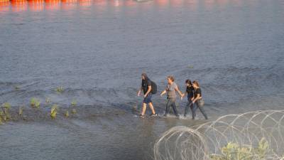 Migrantes siguen cruzando el río Bravo pese a la barrera de boyas colocadas por las autoridades de Texas.