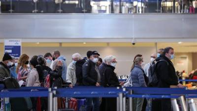Imagen del 28 de diciembre del 2021 de viajeros que esperan en la fila para facturar sus vuelos en la Terminal Internacional Tom Bradley del Aeropuerto Internacional de Los Ángeles.
