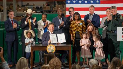 El Gobernador Ron DeSantis muestra la proclamación de la ley de inmigración tras su firma en Jacksonville, Florida.