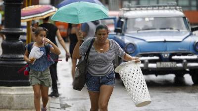 Personas fueron registradas este lunes en La Habana (Cuba) al protegerse de la lluvia, antes del paso de huracán Michael, EFE