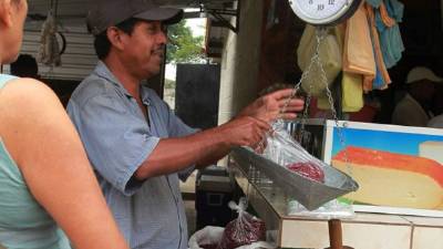 Un vendedor de frijoles ofrece el producto a los clientes en el mayoreo de Tegucigalpa.