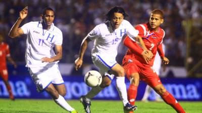 Los seleccionados hondureños Jerry Bengtson y Roger Espinoza pelean el balón con un jugador panameño.