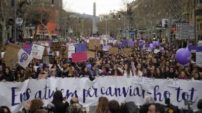 Manifestantes marchan con una pancantarta escrita en Catalán que dice 'Nosotras nos detenemos para parar todo '