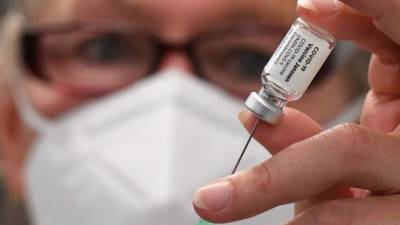 An assistant prepares a Johnson & Johnson Janssen Covid-19 vaccine in a so-called 'Impfzug' (vaccination train) operated by Berliner S-Bahn in Gruenau near Berlin on August 30, 2021, at the start of a vaccination campaign on Berlin's circular Ringbahn railway. (Photo by Tobias Schwarz / AFP)