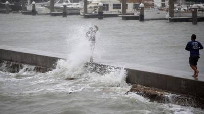 CORPUS CHRISTI, TX - AUGUST 25: A person is hit by a wave churned up by approaching Hurricane Harvey on August 25, 2017 in Corpus Christi, Texas. Hurricane Harvey has intensified into a hurricane and is aiming for the Texas coast with the potential for up to 3 feet of rain and 125 mph winds. Joe Raedle/Getty Images/AFP== FOR NEWSPAPERS, INTERNET, TELCOS & TELEVISION USE ONLY ==
