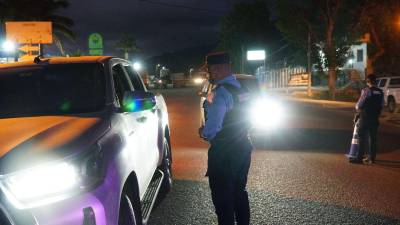 Un policía en la calle inspecciona un vehículo.
