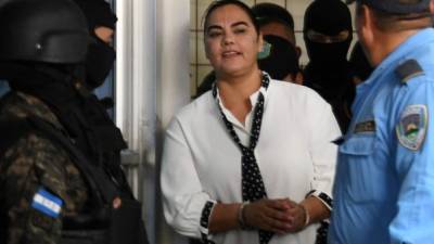 The wife of Honduran former president (2010-2014) Porfirio Lobo, Rosa Elena de Lobo -accused of misappropriation of public funds, illicit association and money laundering- is escorted upon arrival at a corruption court in Tegucigalpa on March 2, 2018. / AFP PHOTO / ORLANDO SIERRA