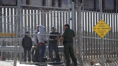 Un agente de la Patrulla Fronteriza de EEUU conversa con inmigrantes detenidos en la frontera de los Estados Unidos y México. AFP