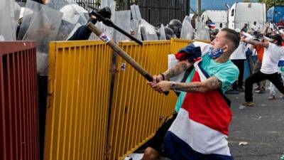 Manifestantes atacaron a la policía con palos y piedras frente a la Casa Presidencial de Costa Rica./AFP.