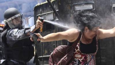 Un policía rocía con gas a una manifestante en Río de Janeiro. Foto: EFE/Antonio Lacerda