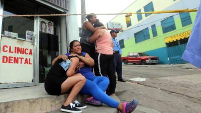 Familiares de Fernando Mejía lloran su muerte en la esquina opuesta al mercado Mama Chepa.