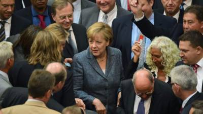 La canciller alemana, Ángela Merkel en medio de los diputados del Parlamento.