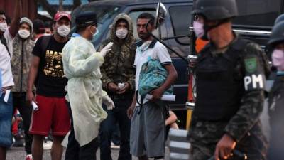 A San Pedro Sula, en el norte del país, arribaron 102 adultos y 14 menores no acompañados, quienes también fueron puestos en cuarentena por 14 días. Fotos AFP