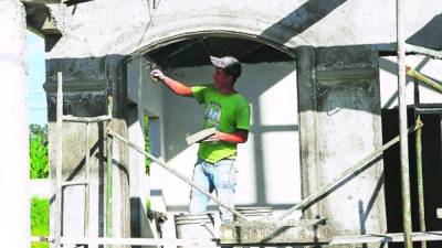 Un obrero aplica la capa de cemento en el relleno de una casa. Se espera que el sector construcción se dinamice.