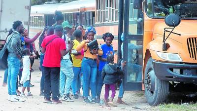 Migrantes de varias nacionalidades abordando buses cerca de la frontera entre Honduras y Nicaragua.