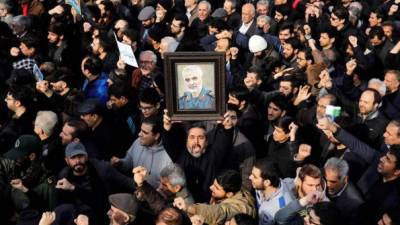 Un manifestante fue registrado este viernes al alzar un retrato del difunto comandante de la Fuerza Quds de los Guardianes de la Revolución de Irán, Qasem Soleimaní, durante una protesta multitudinaria contra EE.UU., en Teherán (Irán). EFE/Abedin Taherkenareh