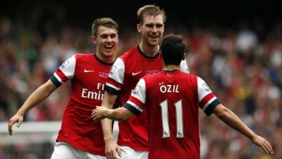 Mesut Özil, Aaron Ramsey y Per Mertesacker celebran un gol ante Stoke City.