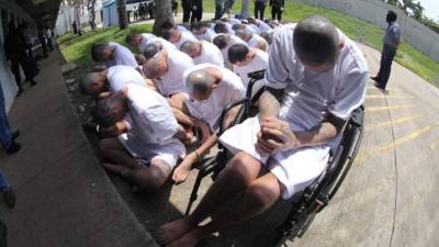 Handout picture released on April 26, 2020 by El Salvador's Presidency press office showing inmates at the Izalco prison, northwest of San Salvador, during a security operation within the COVID-19 coronavirus pandemic, after President Nayib Bukele decreed a maximum emergency in all penitentiary centers housing gang members. - Bukele ordered the director general of Penitentiary Centers, Osiris Luna Meza, to decree a maximum emergency, following intelligence reports detailing that the recent increase in homicides in the country was registered by orders issued from prisons. (Photo by El salvador Presidency press office / EL SALVADOR'S PRESIDENCY PRESS OFFICE / AFP) / RESTRICTED TO EDITORIAL USE - MANDATORY CREDIT 'AFP PHOTO / EL SALVADOR'S PRESIDENCY PRESS OFFICE ' - NO MARKETING - NO ADVERTISING CAMPAIGNS - DISTRIBUTED AS A SERVICE TO CLIENTS